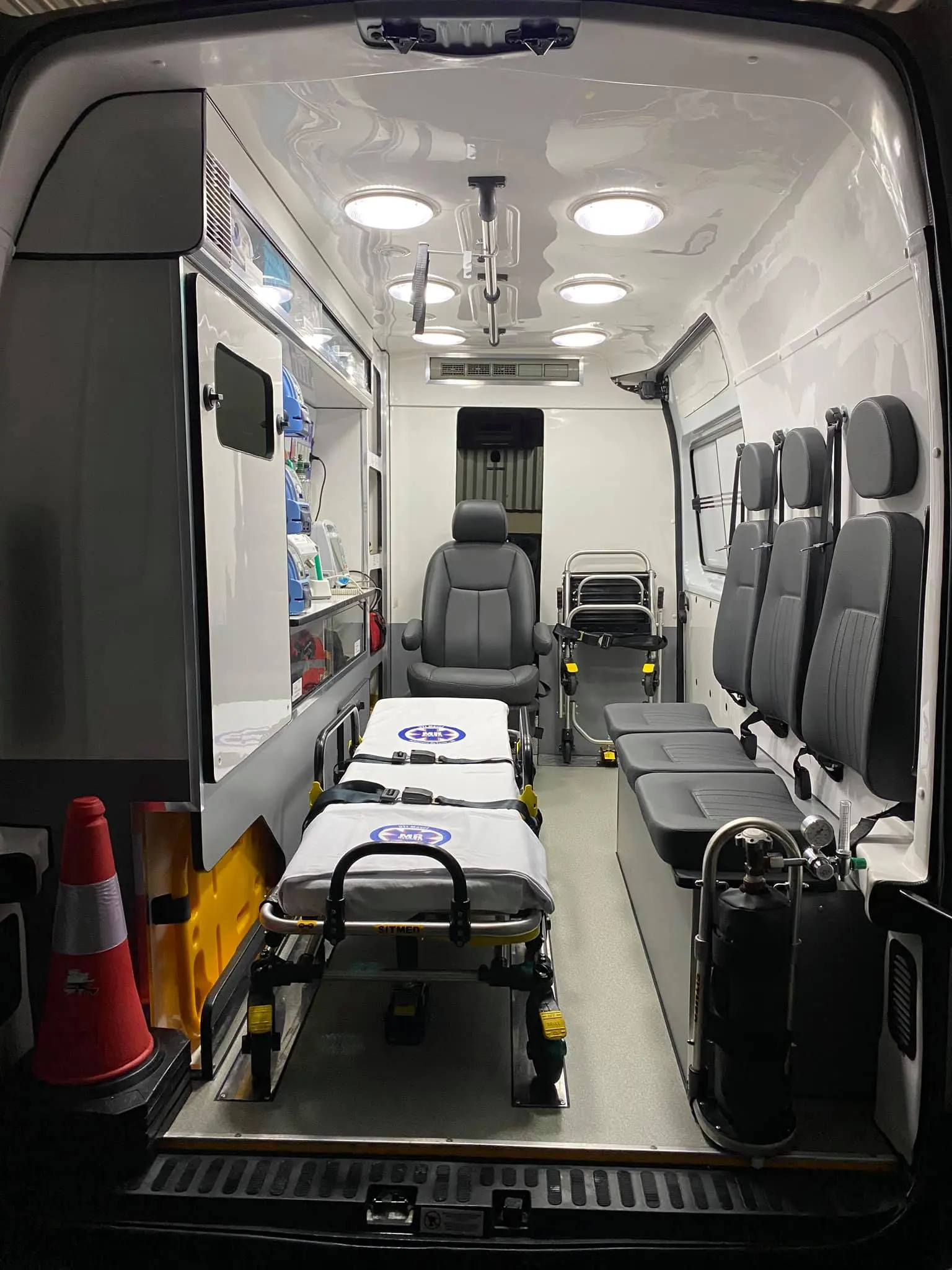 Interior da UTI Móvel da MR Resgate com maca, monitores e equipe médica a bordo
